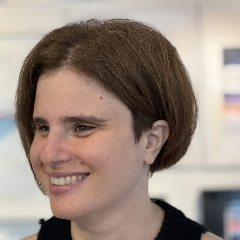 Headshot of Tasha Chemel. She has brown hair and brown eyes and is smiling while looking off to the left